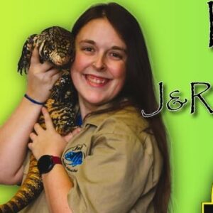 A person holding a large lizard