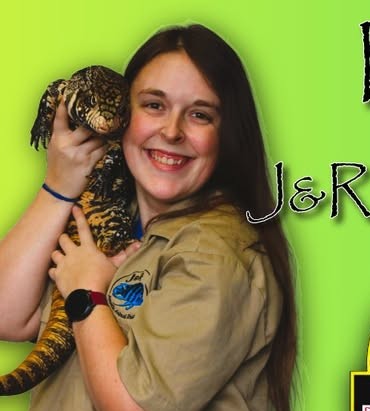 A person holding a large lizard